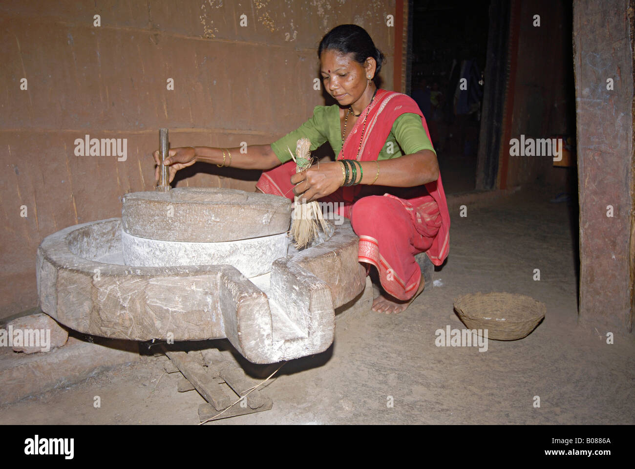 Les femmes tribales Warli le meulage du riz. Banque D'Images
