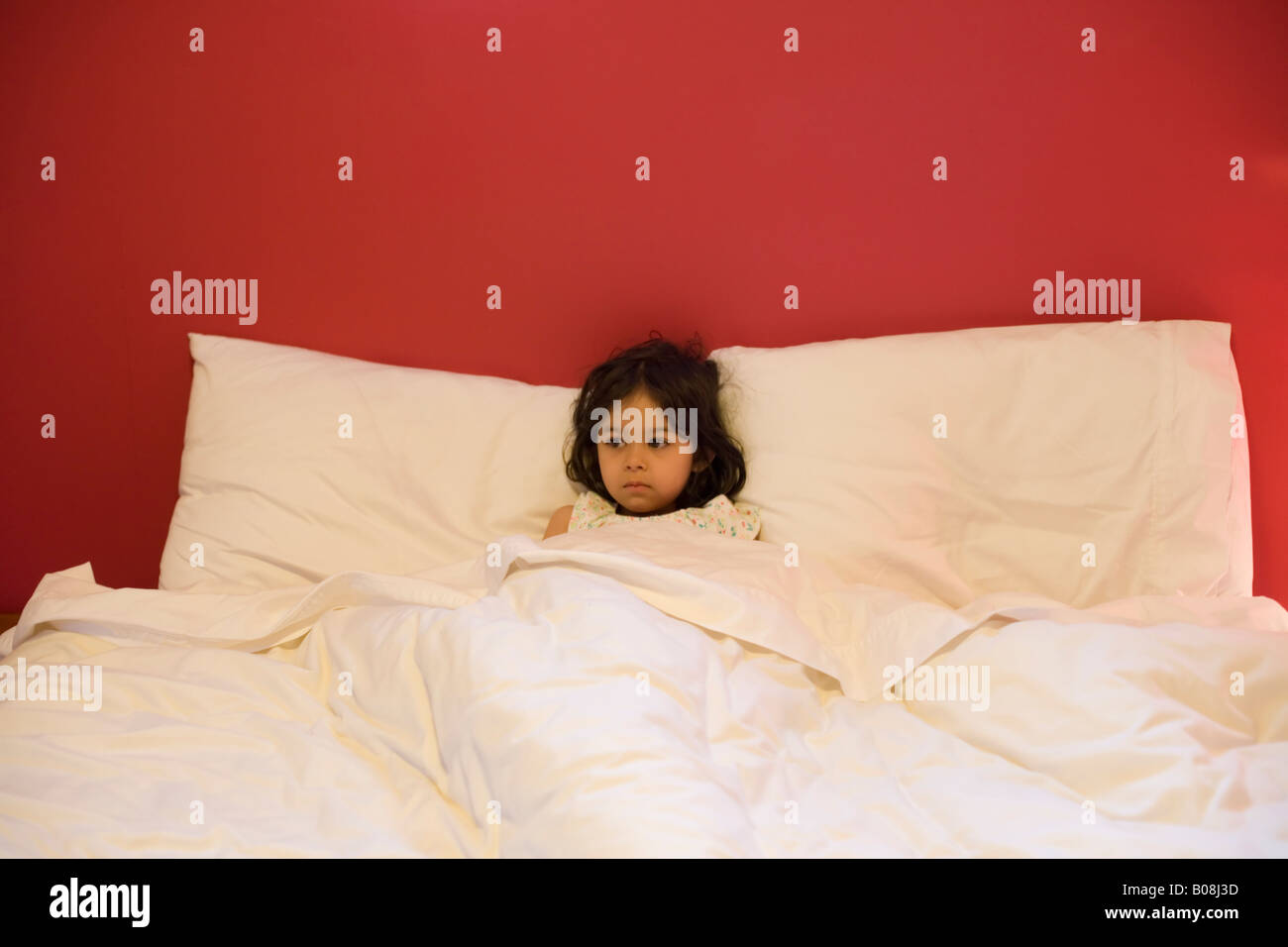 Jeune fille âgée de 4 ans se trouve dans un lit double Photo Stock - Alamy
