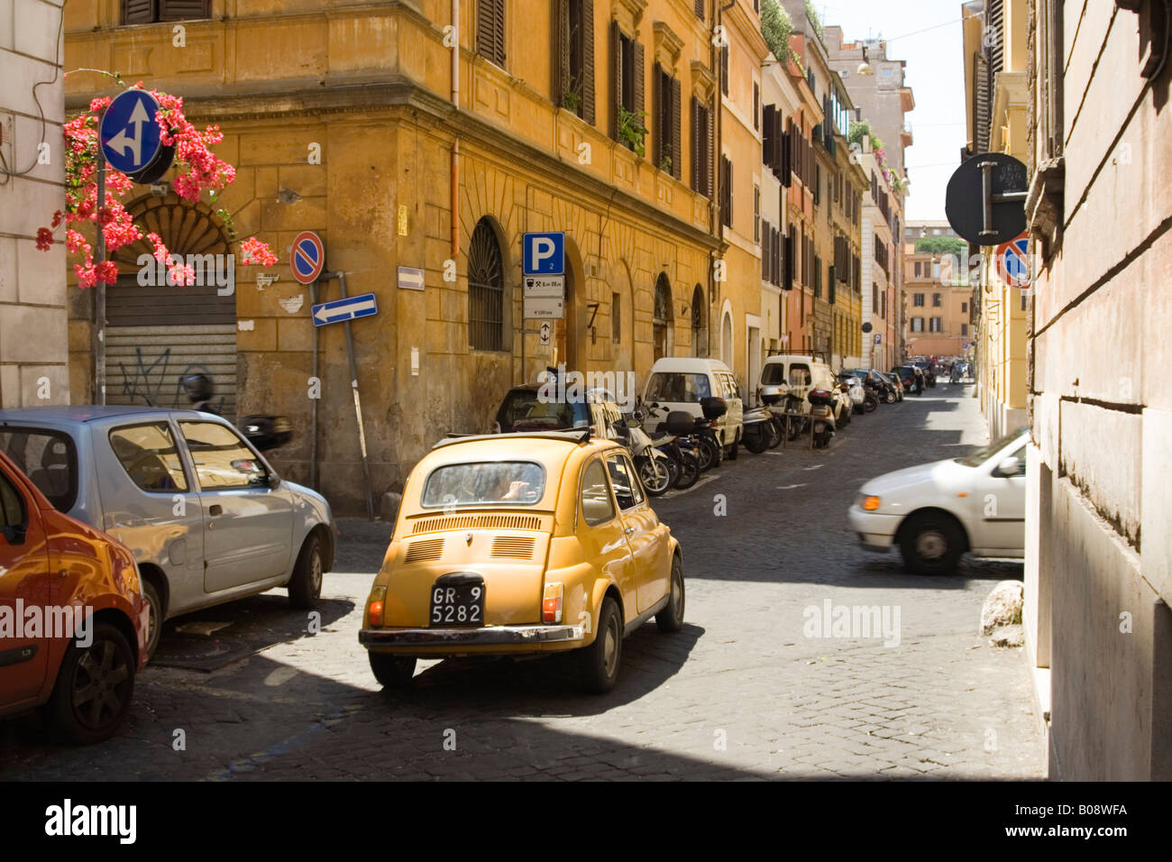 Fiat 500 jaune dans une longue rue étroite, Rome, Italie Banque D'Images