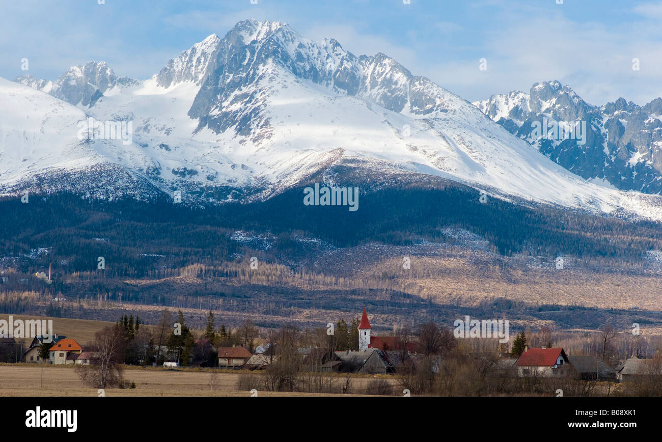 Village au pied de la chaîne des Carpates enneigées, Zdiar peaks près de Tatranská Lomnica, Slovaquie Banque D'Images
