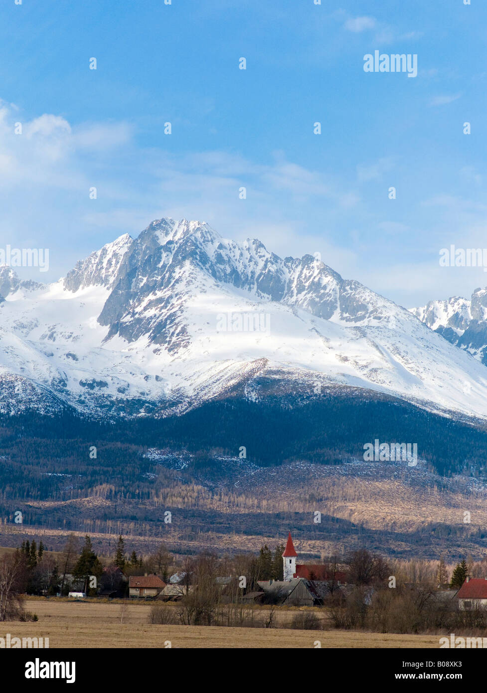 Village au pied de la chaîne des Carpates enneigées, Zdiar peaks près de Tatranská Lomnica, Slovaquie Banque D'Images