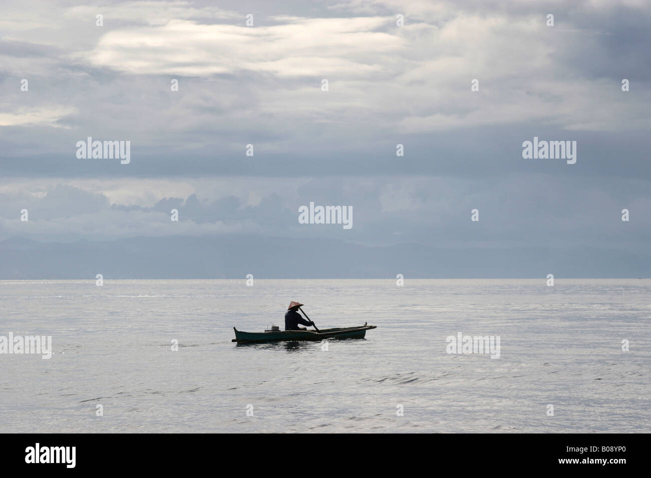 Pêcheur dans une barque à aller en mer, Philippines Banque D'Images