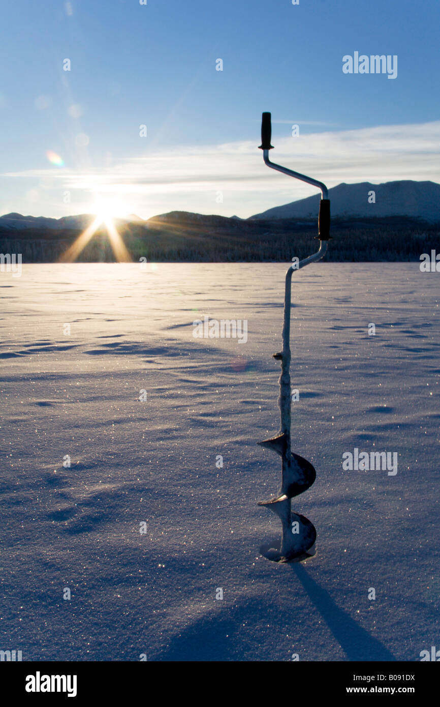 La vis de la glace utilisée pour couper un trou pour la pêche sur glace, Fox Lake, Yukon Territory, Canada Banque D'Images