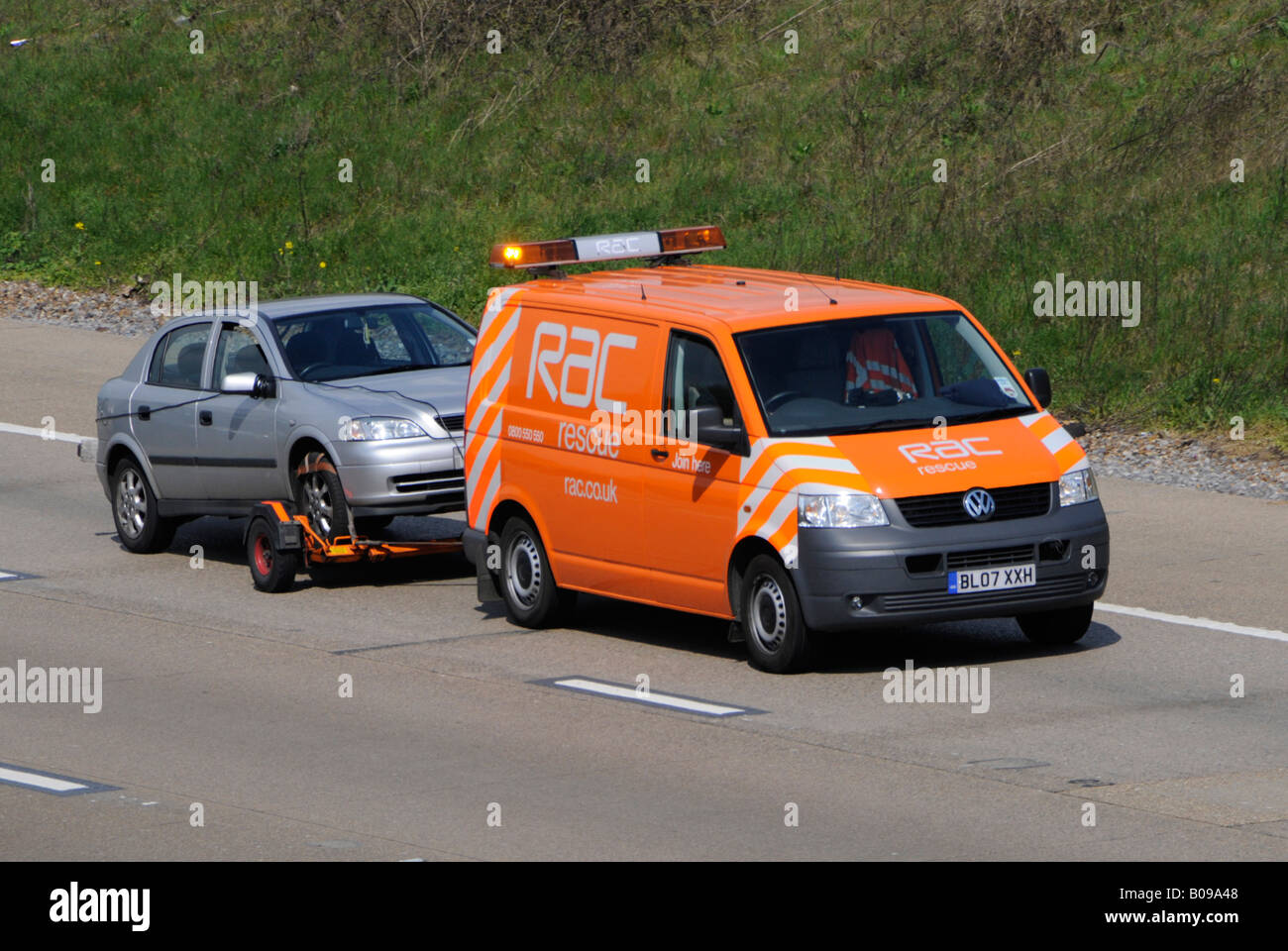 RAC VW Volkswagen break business van & conducteur côté & vue avant logo de la marque remorquage gris décomposé voiture conduisant le long de la route d'autoroute m25 Angleterre Royaume-Uni Banque D'Images