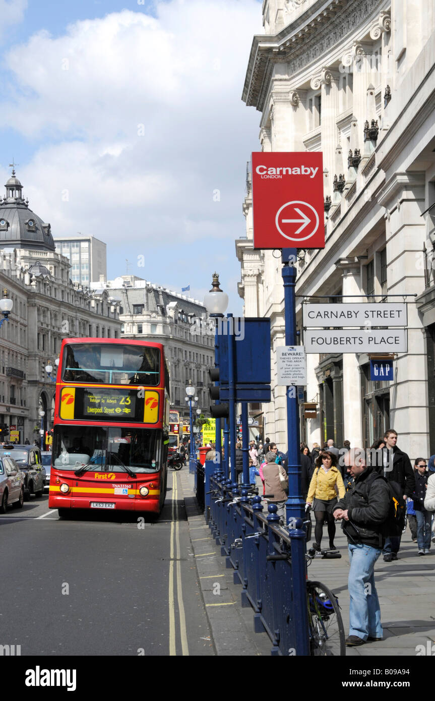 A deux étages, nous et les piétons sur le trottoir dans la scène de Regent Street à West End Londres avec des panneaux pour Carnaby Street et Fouberts place England Banque D'Images