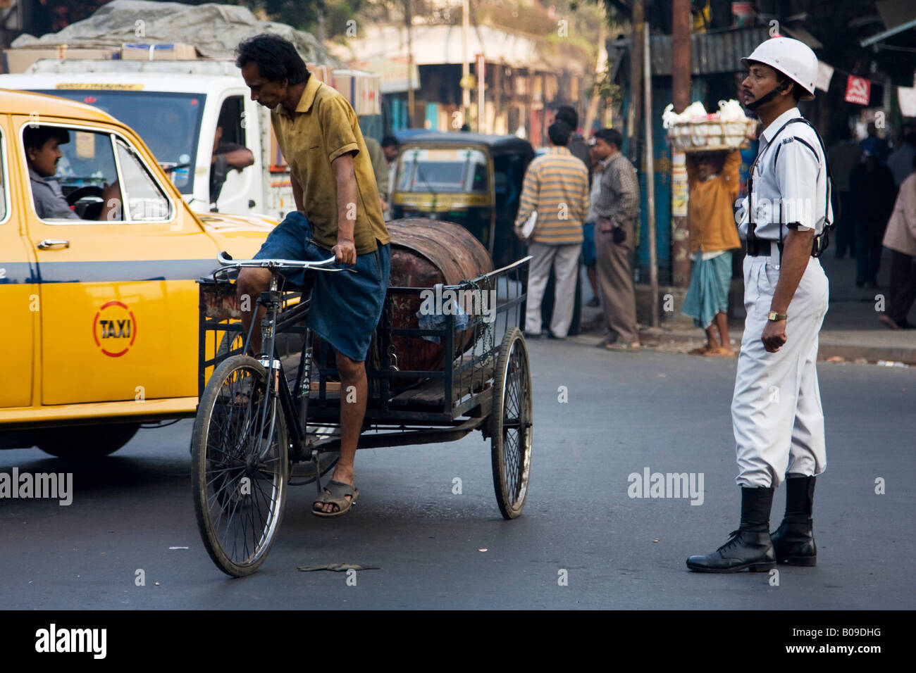 Un agent de la circulation tente de maintenir l'ordre sur une longue route de Calcutta, Inde Banque D'Images
