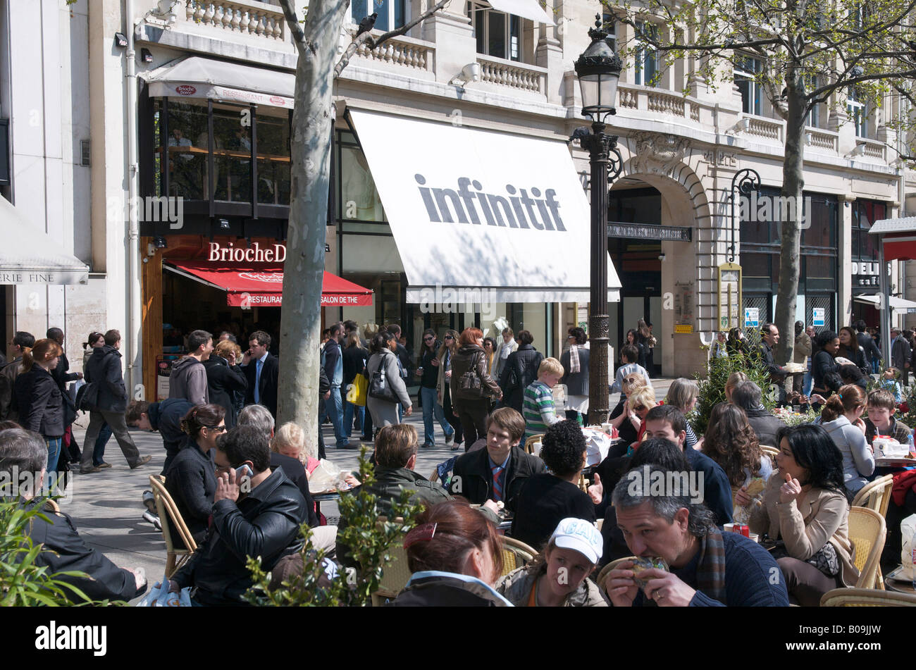 Assis devant les magasins sur les Champs Elysées à Paris Banque D'Images