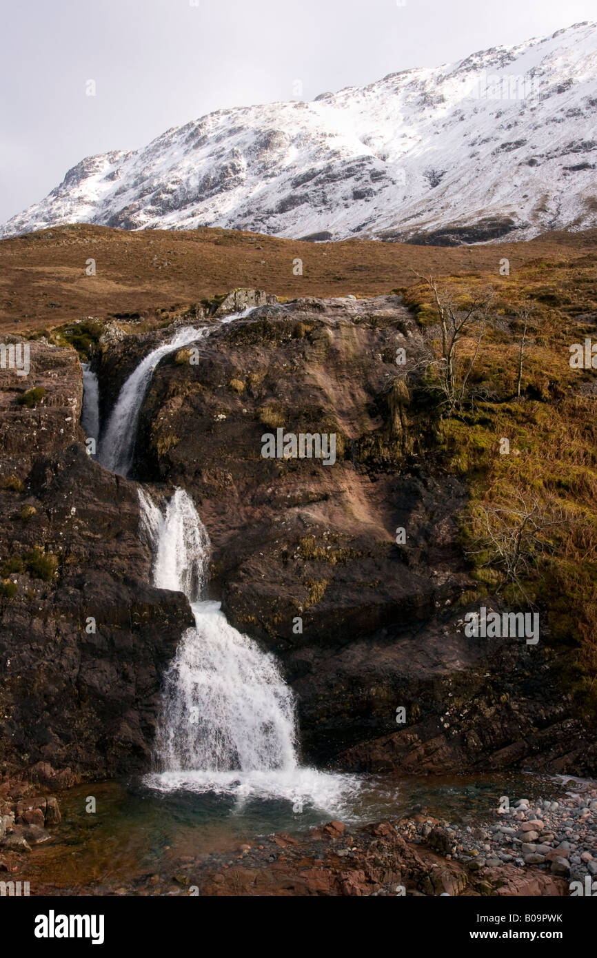 Scottish Highland mountain waterfall avec de la neige dans la région de Glencoe Banque D'Images