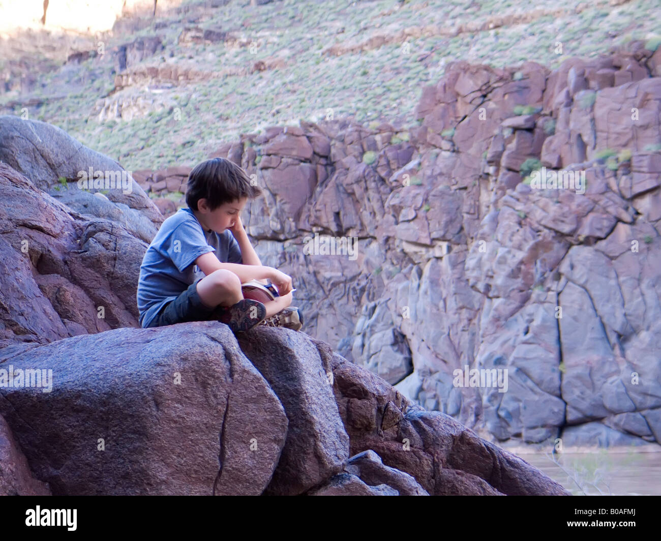 Lit garçon livre tout en randonnée dans le Grand Canyon Banque D'Images