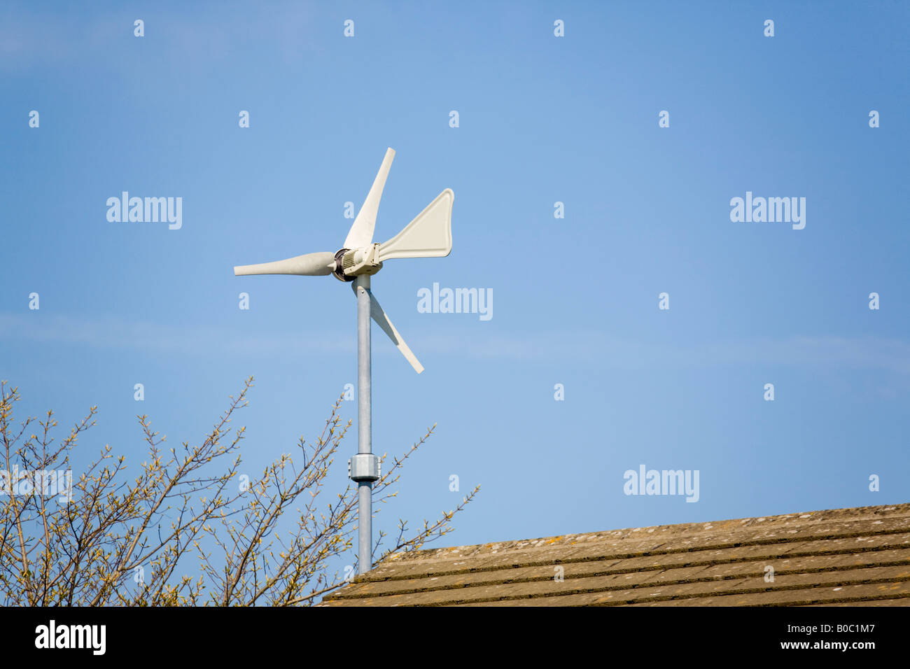 Wndsave micro wind turbine montée sur le mur de la maison au-dessus de toit contre ciel bleu Windsave 1200 se connecte au réseau national de la queue de la lame Banque D'Images