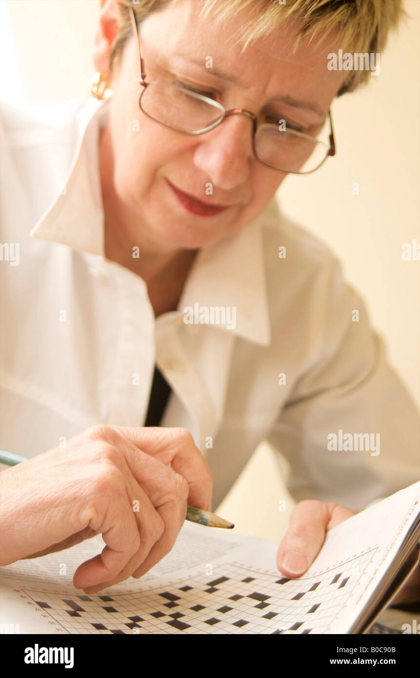 Plus mature woman doing a crossword puzzle Banque D'Images