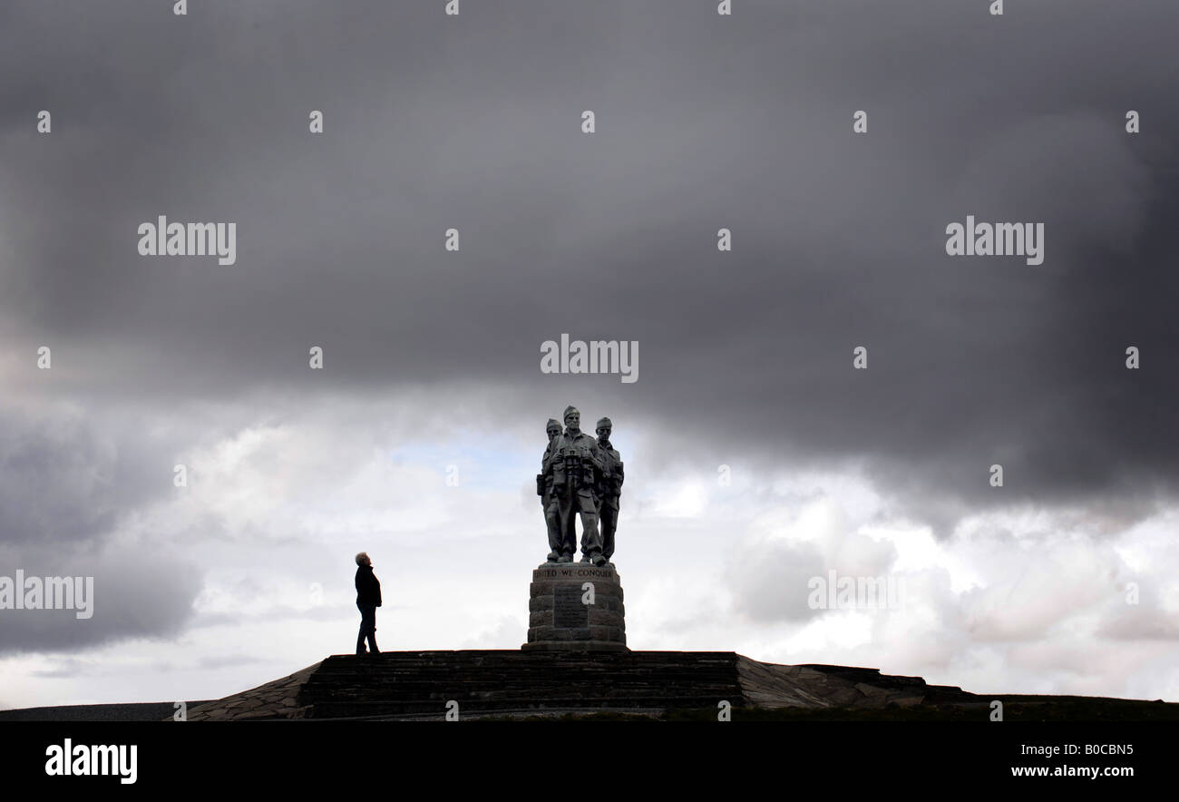 Un touriste SE PENCHE SUR LE RÉGIMENT COMMANDO WAR MEMORIAL SOUS UN CIEL NOIR À SPEAN BRIDGE, PRÈS DE FORT WILLIAM en Ecosse, Royaume-Uni. Banque D'Images