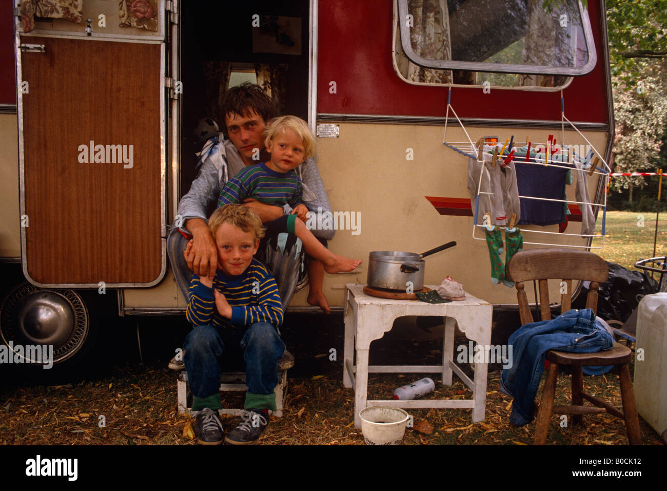 Un interprète de l'art budget circus Snapdragon est assis avec sa famille sur le pas de sa caravane à la maison avant le prochain salon Banque D'Images