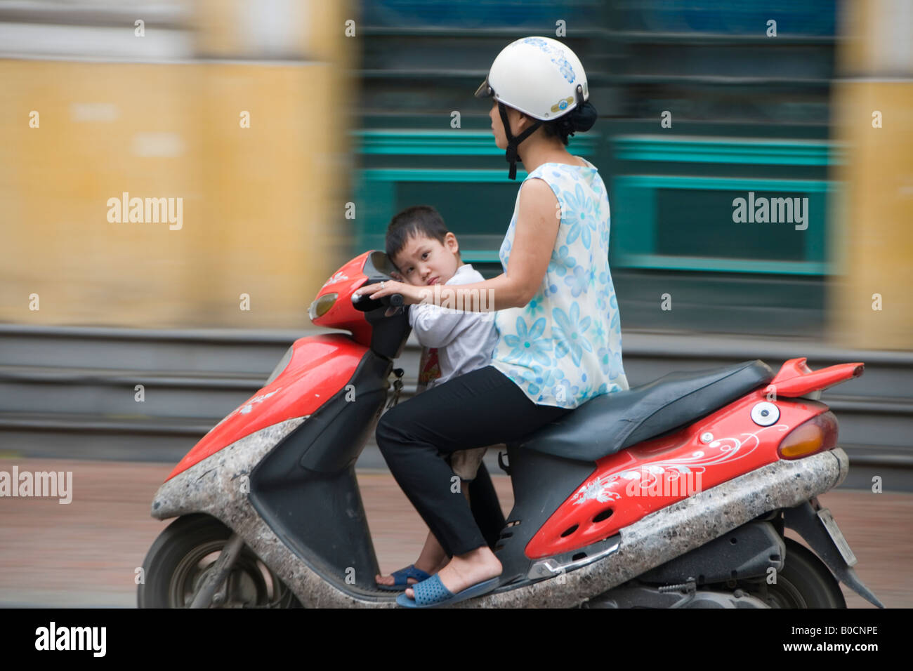 Femme et un garçon fatigué sur un scooter sur Trang Tien, Hanoi, Vietnam Banque D'Images