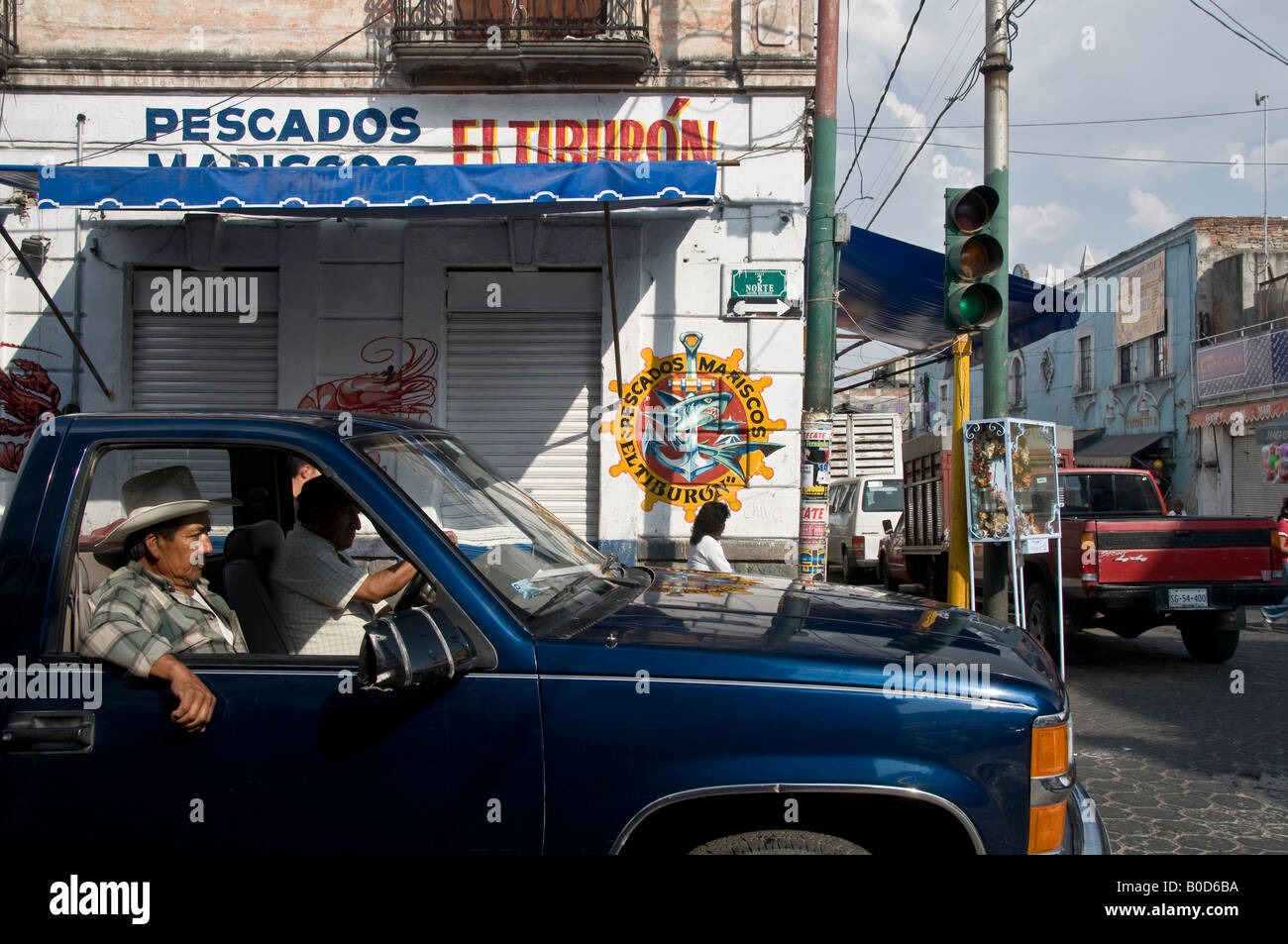 Deux mexicains assis dans vieille camionnette en attente au feu. L'un portant un chapeau Stetson de cow-boy. Banque D'Images