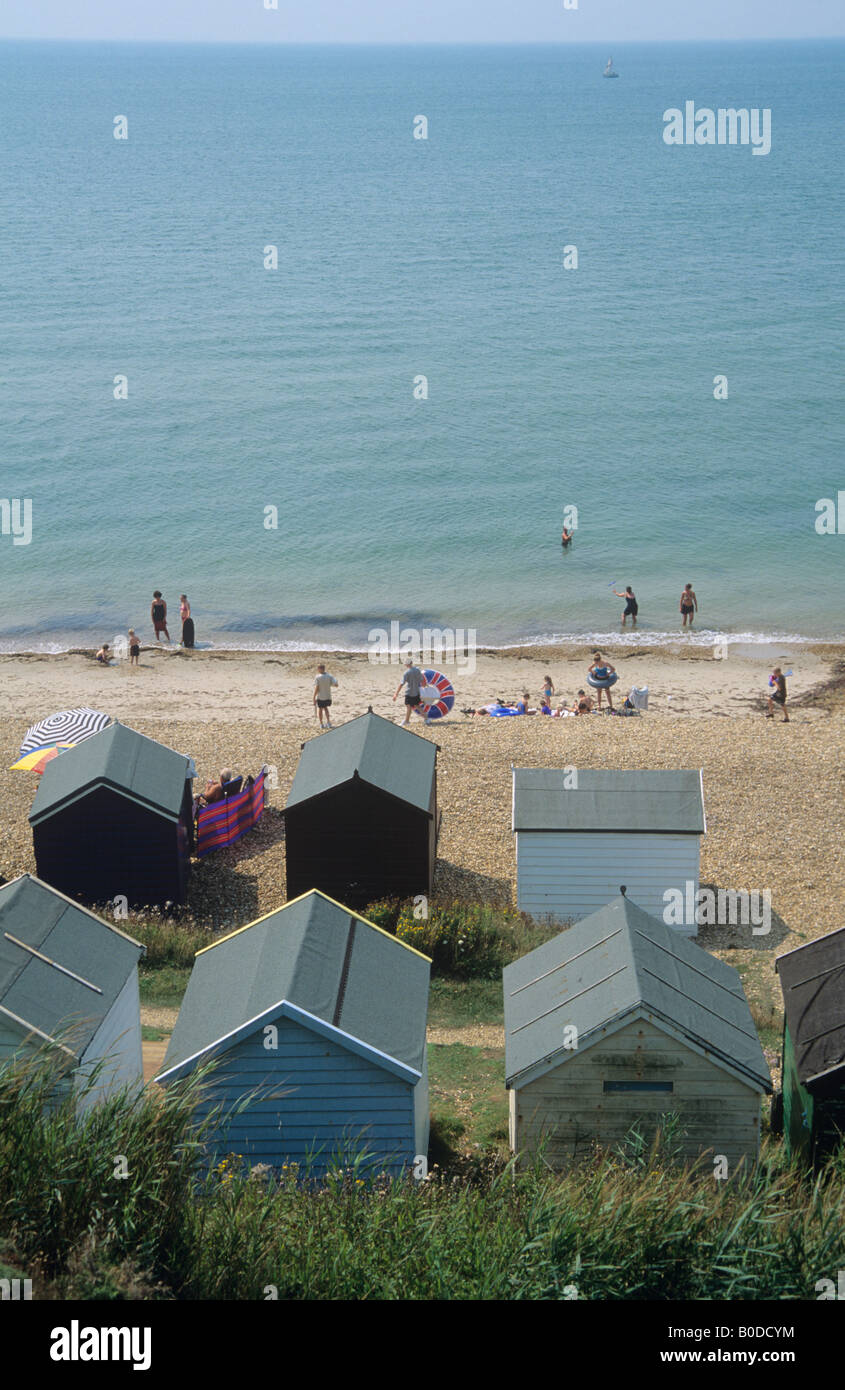 Les vacanciers et cabines de plage, de la côte du Dorset. Banque D'Images