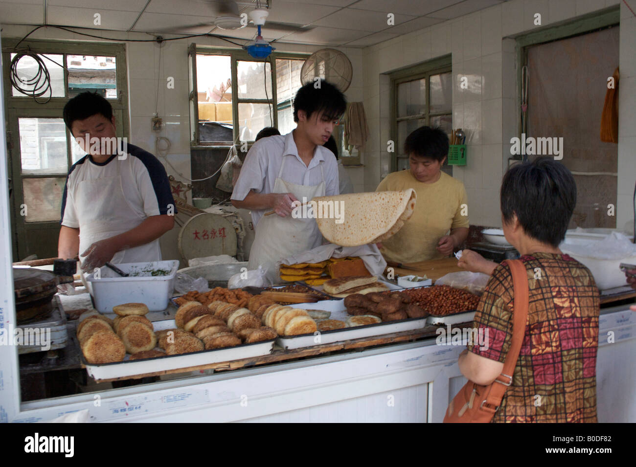 Une femme achète des crêpes frits et des en-cas d'un décrochage Beijing Chine Banque D'Images