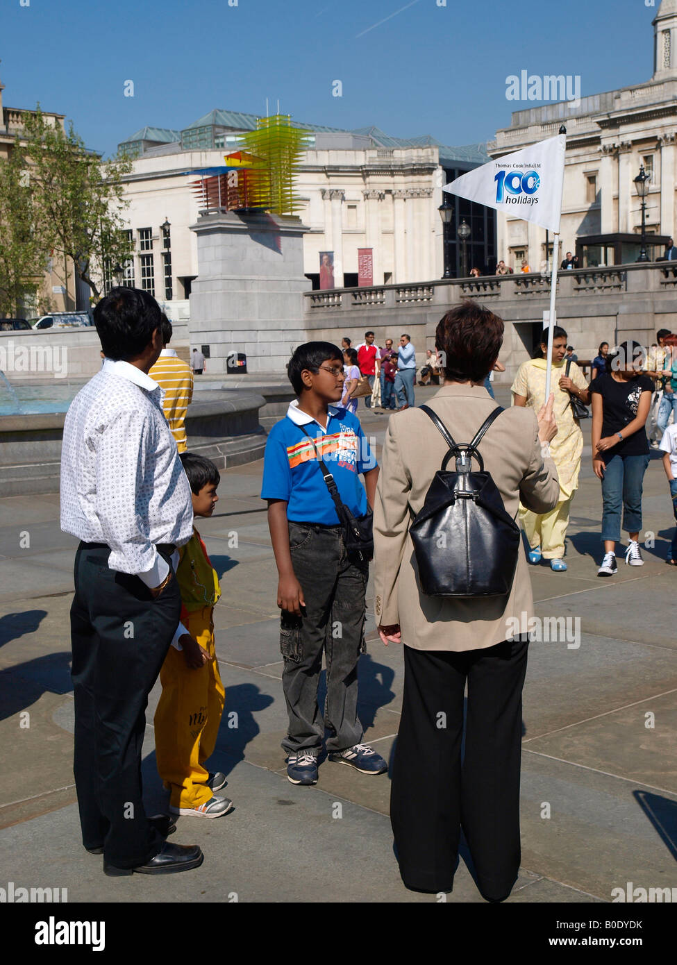 Un guide nous tend un drapeau pour recueillir des clients pour un tour. Trafalgar Square London Banque D'Images
