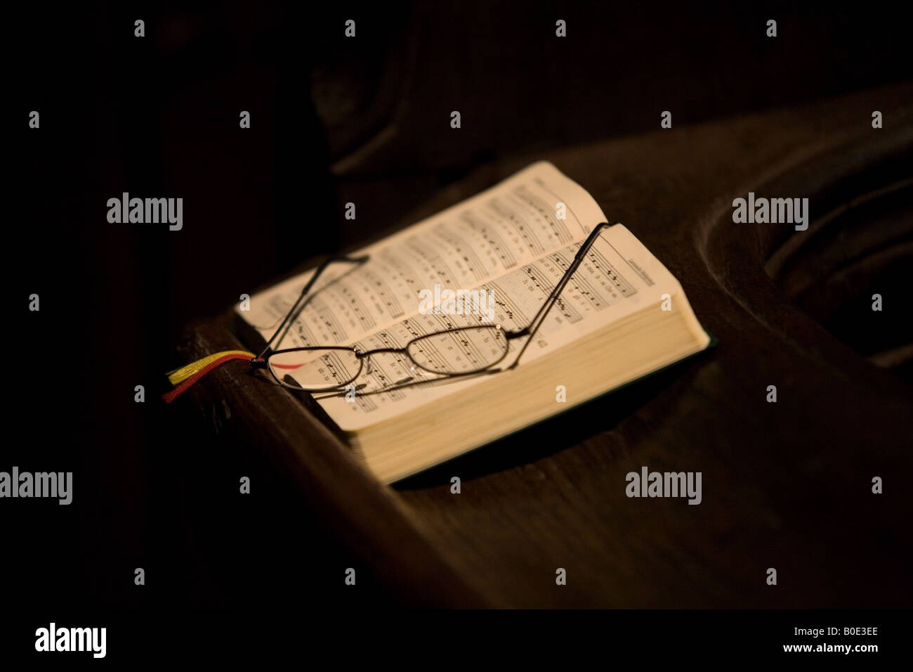 Un livre des Psaumes et d'un ensemble de verres sur un banc dans une église. Banque D'Images