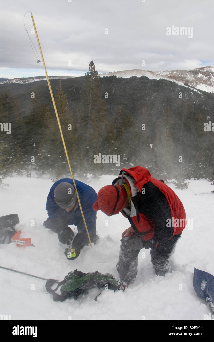 Récupération d'Avalanche ski- en utilisant un phare et un pôle de la sonde dans la neige à la recherche d'une victime ensevelie Banque D'Images