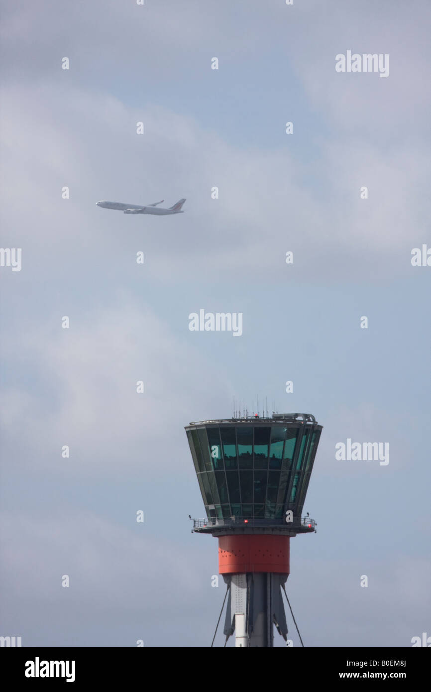 Tour de contrôle de l'air et vol d'un avion de passagers de Londres Heathrow dans l'arrière-plan. Banque D'Images