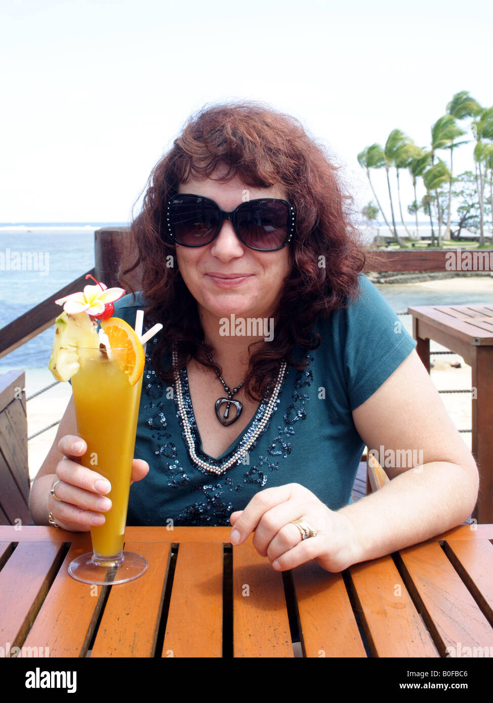 Une dame en sirotant un cocktail de prendre un verre DANS UN COMPLEXE DE VACANCES ÎLE FIDJIENNE BDA VERTICAL11501 Banque D'Images