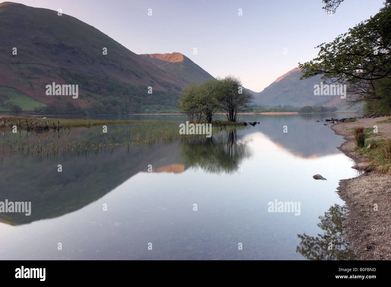 L'aube La lumière frappe les montagnes au-dessus de l'eau, Frères du Lake District, Cumbria. UK Banque D'Images