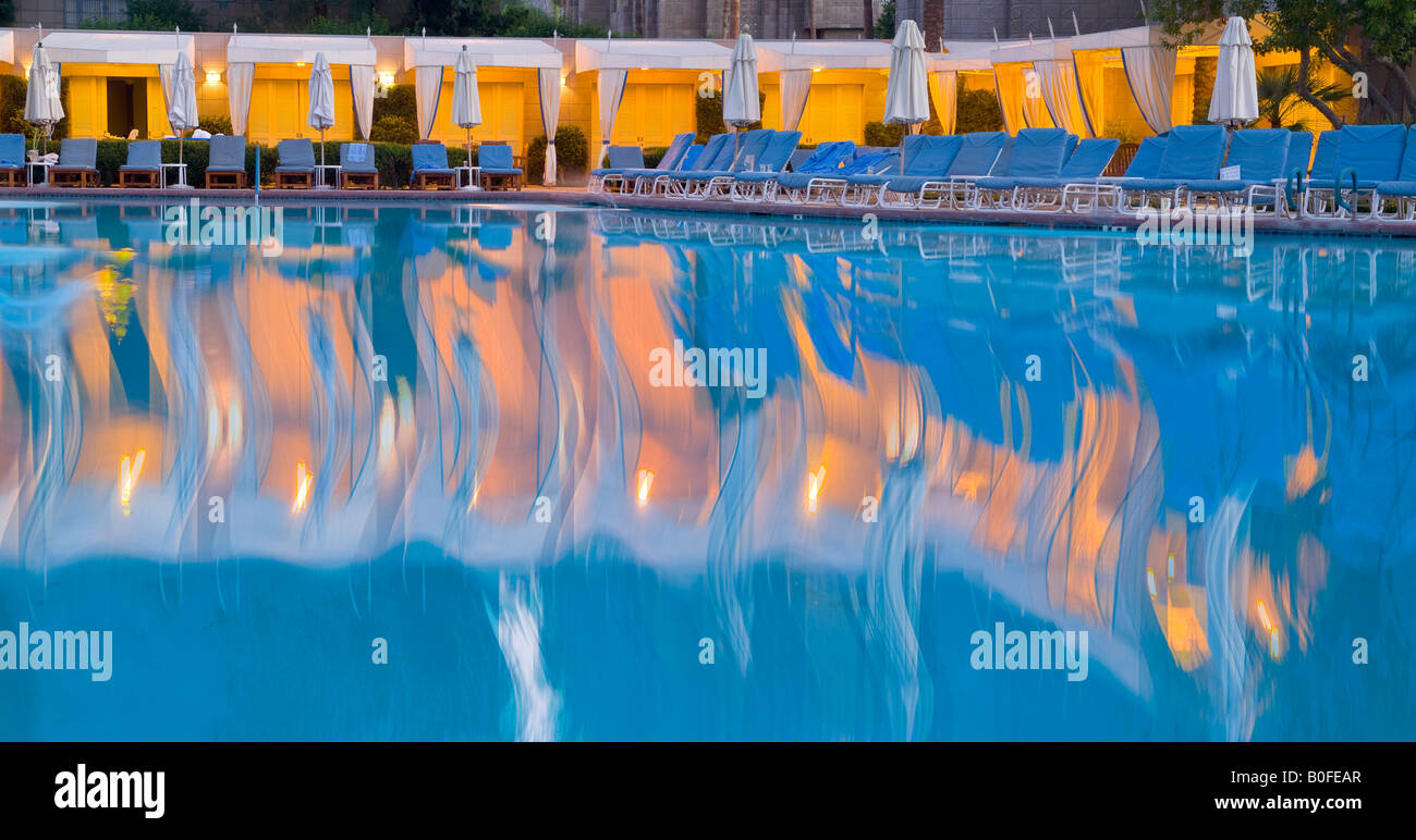 Resort Hotel Piscine avec flou de mouvement ondulé Réflexions et président-salons dans la soirée Banque D'Images Resort Hotel Piscine avec flou de mouvement ondulé Réflexions et président-salons dans la soirée Banque D'Images