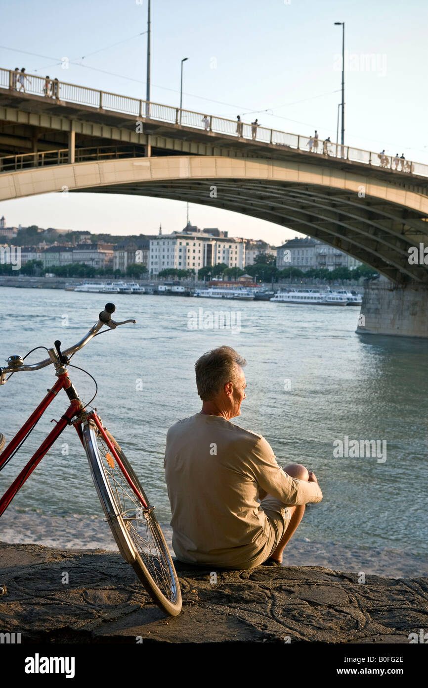 Homme assis tout seul par river Banque D'Images