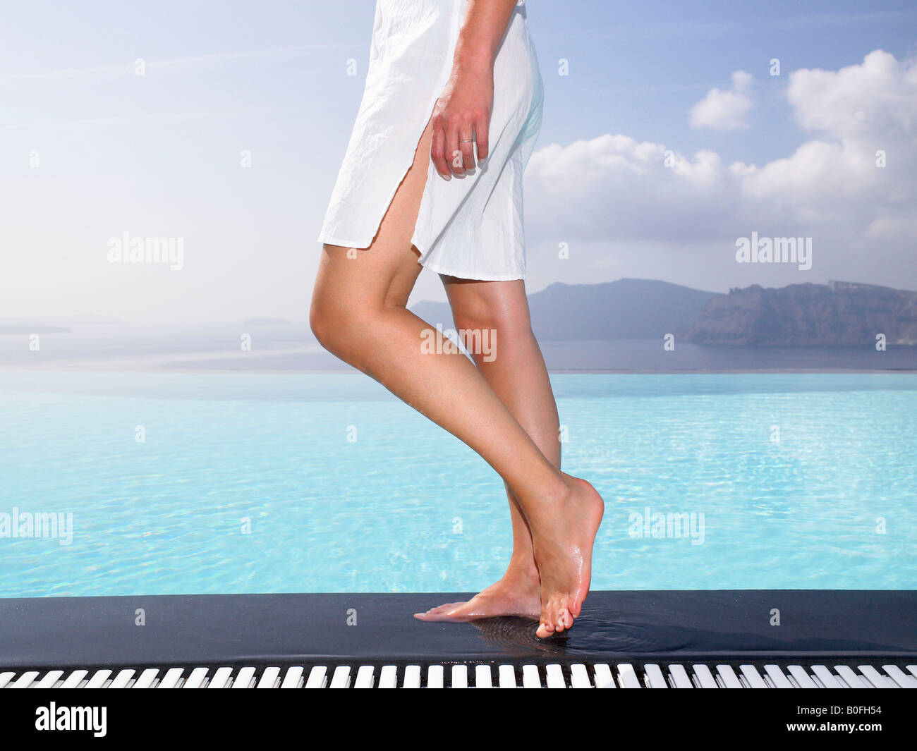 Les jambes de la femme sur le bord d'une piscine Banque D'Images