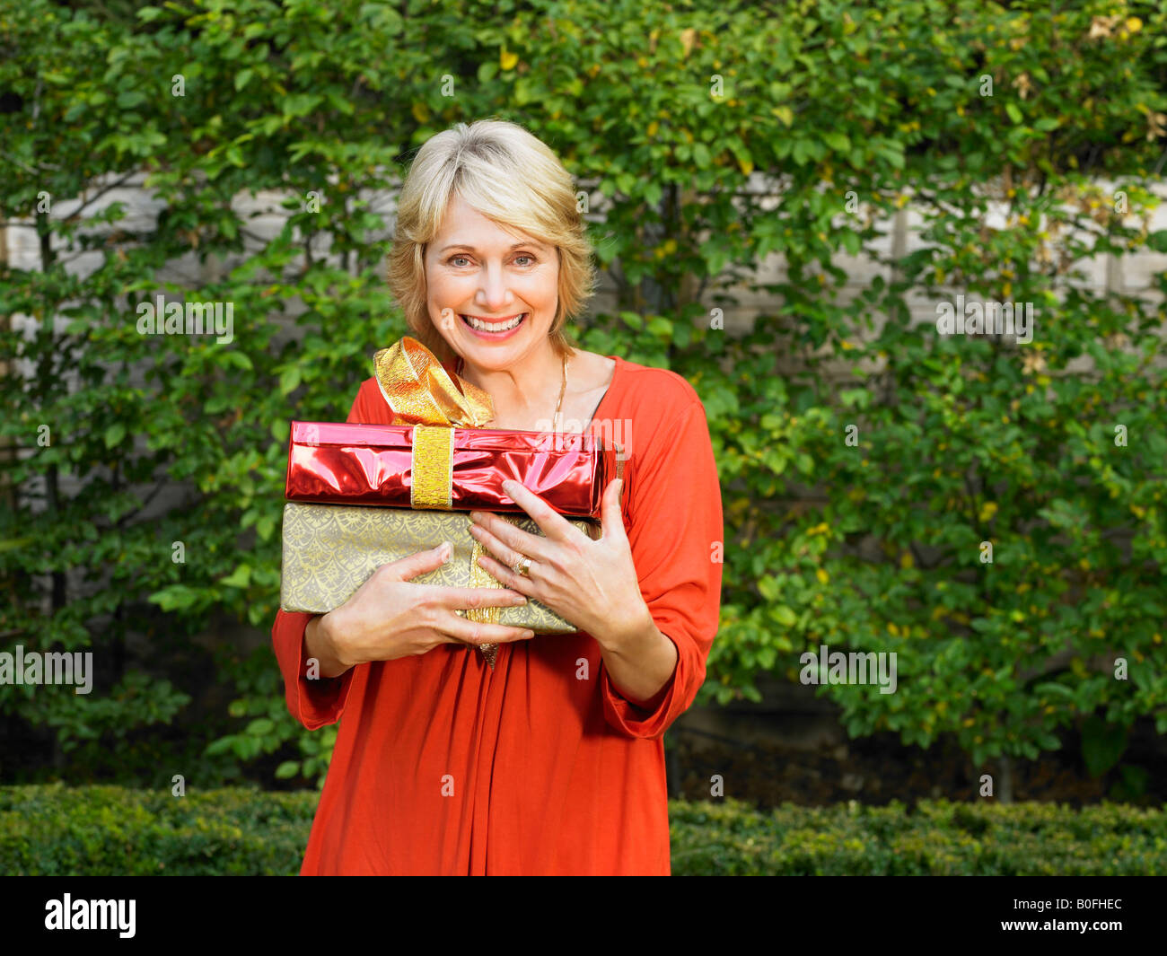 Senior woman holding presents Banque D'Images