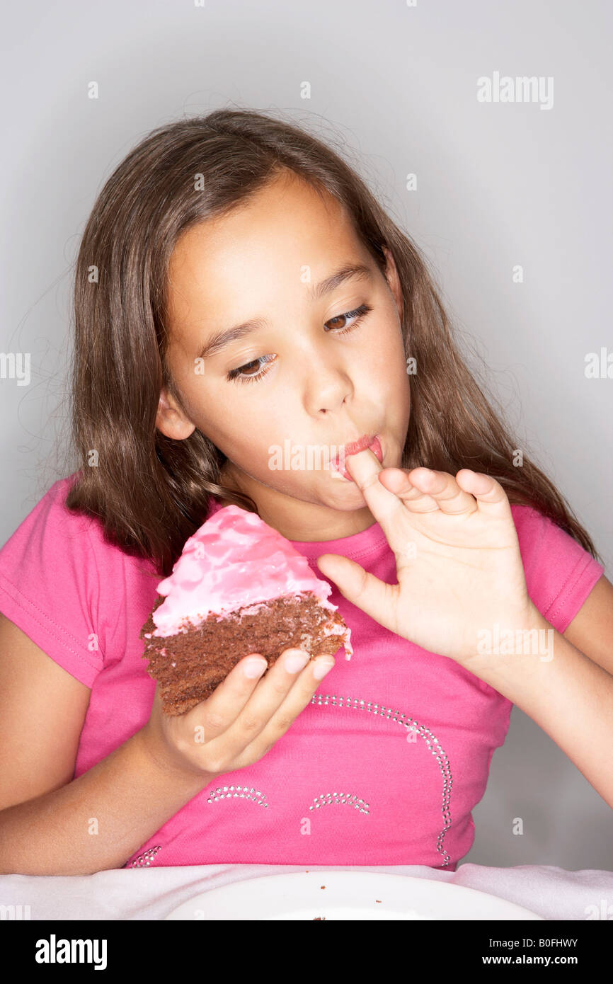 Girl eating tranche de gâteau Banque D'Images