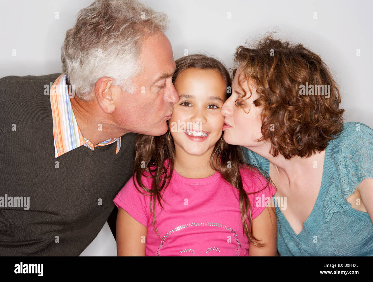 Grand-papa et maman s'embrasser la joue de la jeune fille Banque D'Images