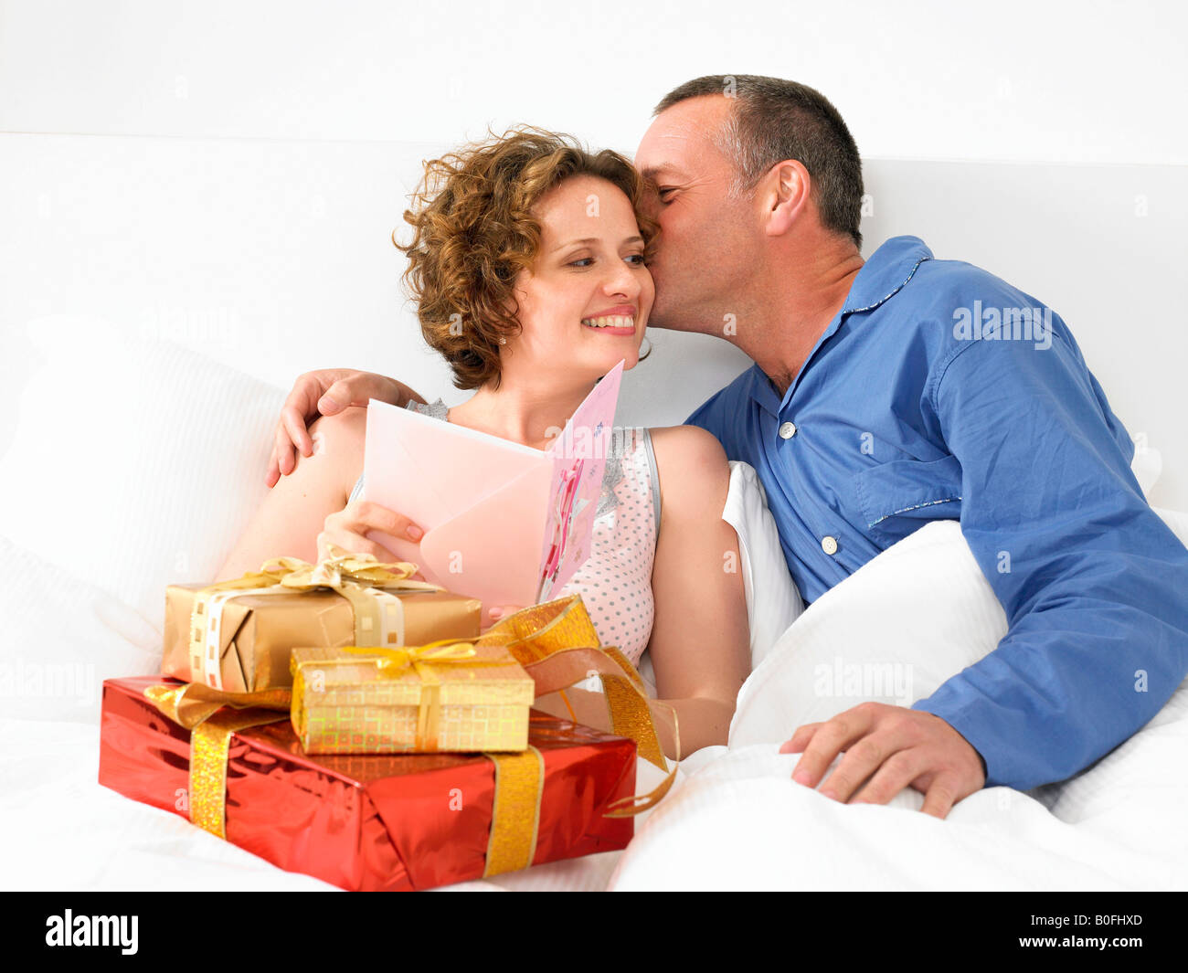 Man kissing woman in bed Banque D'Images