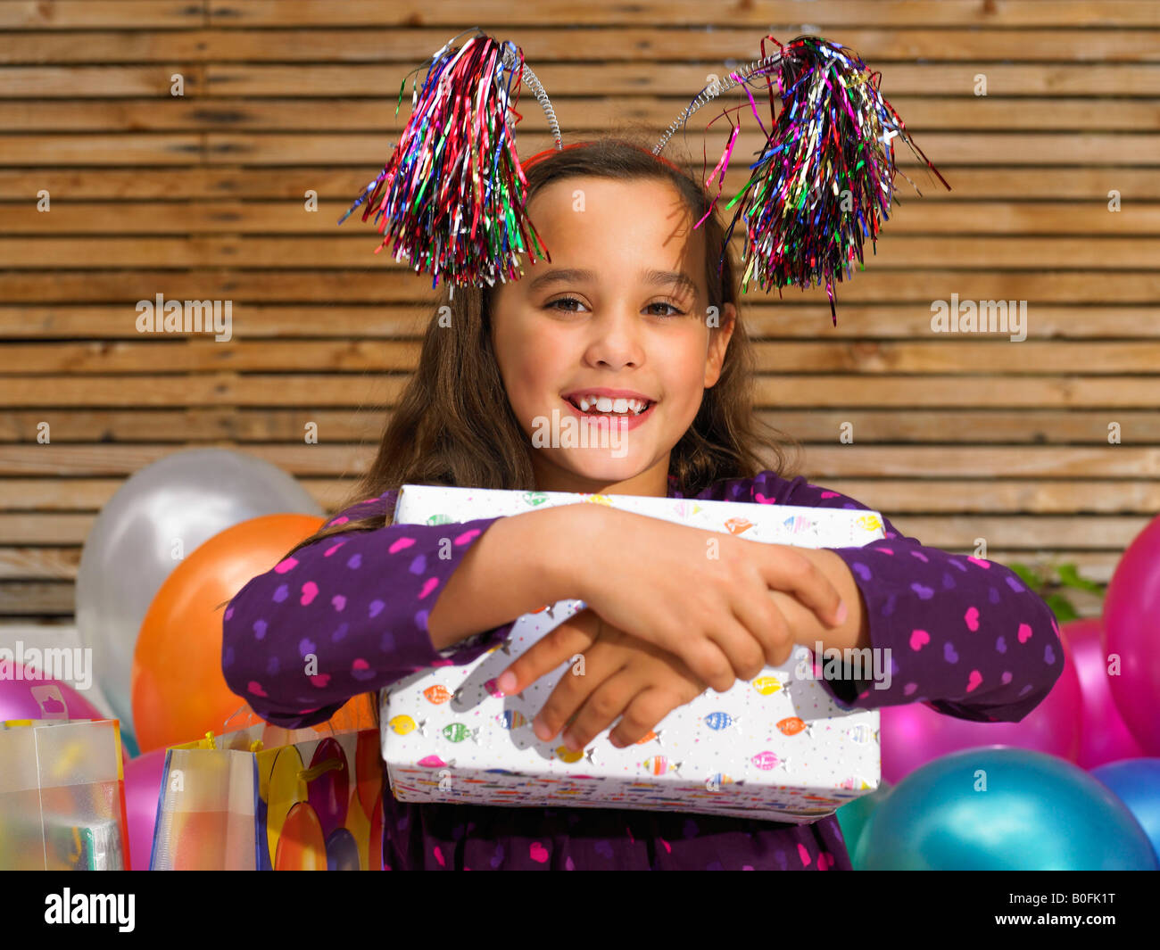 Girl (5-6) holding birthday present Banque D'Images