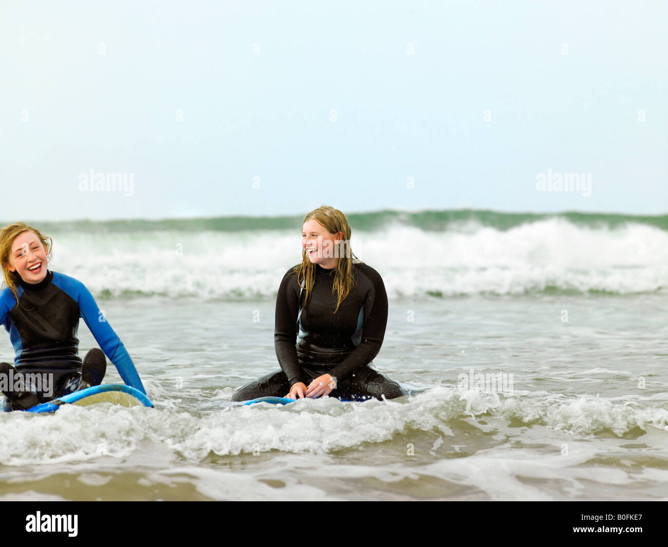 Assis sur des planches de surf féminin Banque D'Images