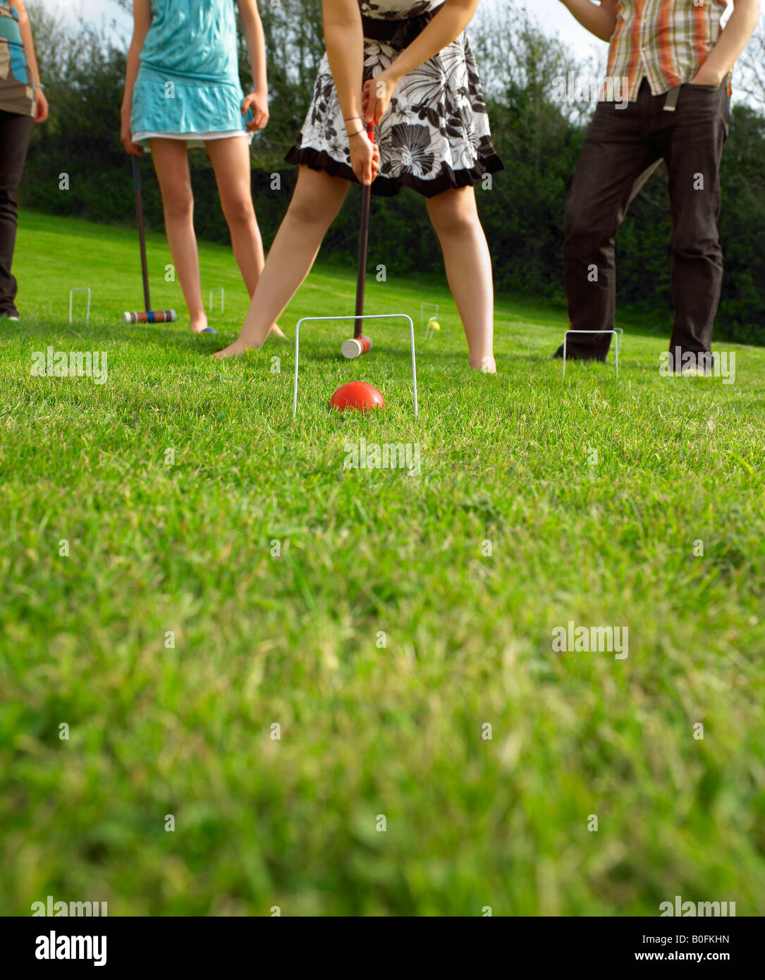 L'homme et de femmes jouant au croquet dans le jardin Banque D'Images