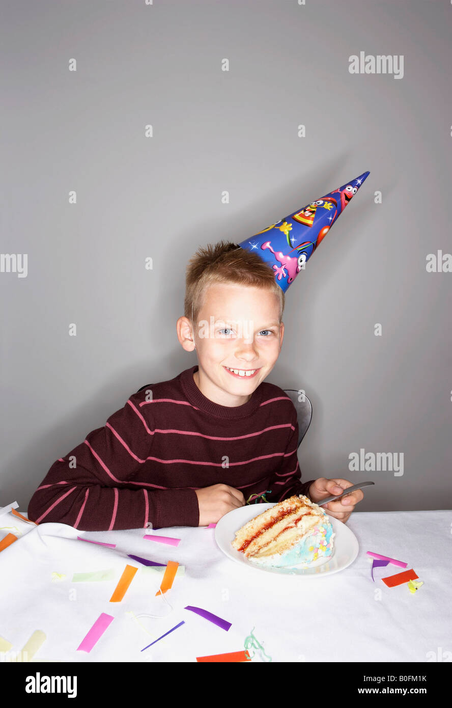 Garçon (8-10) avec tranche de gâteau d'anniversaire Banque D'Images