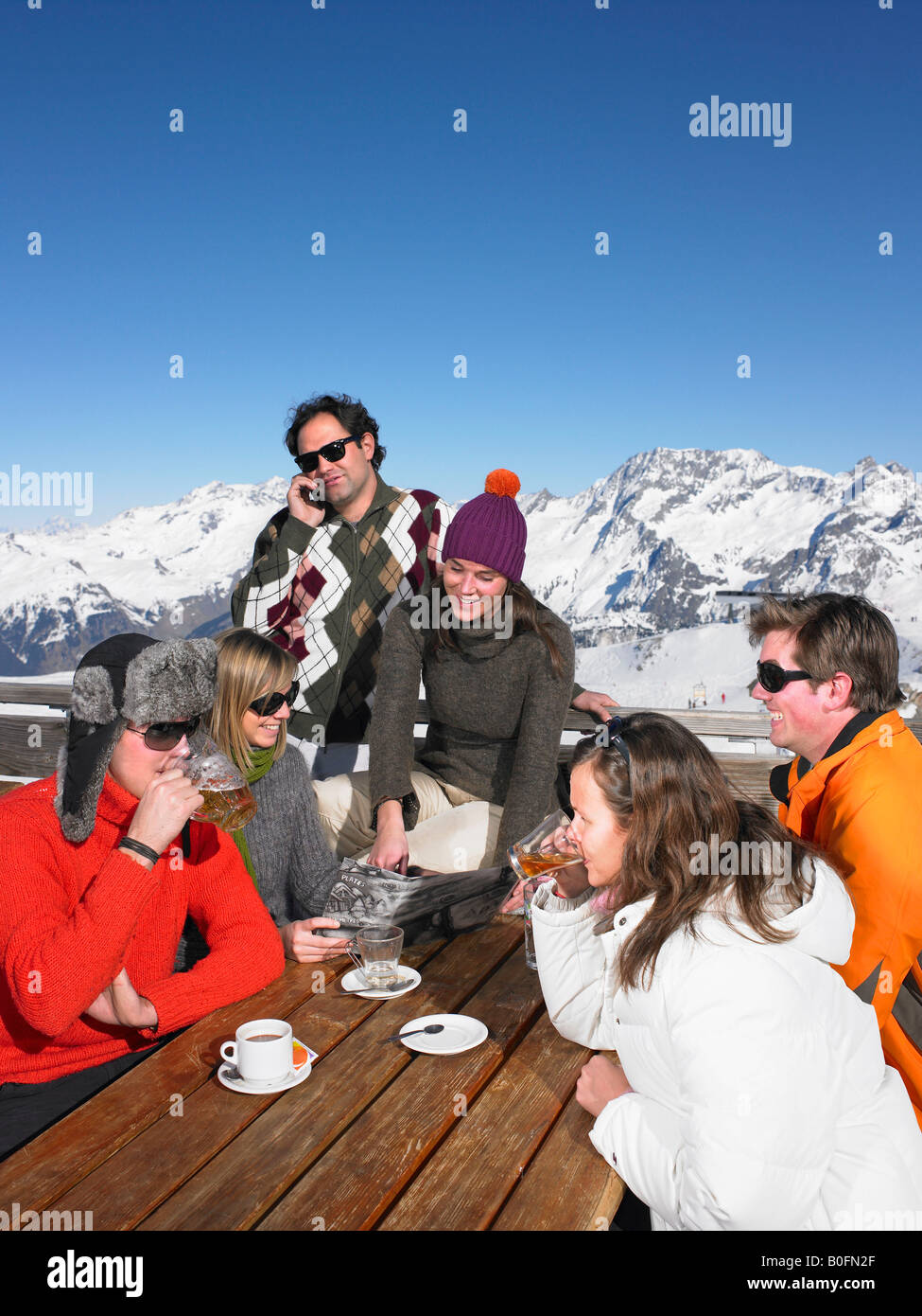 Personnes assises en train de boire un verre en terrasse en souriant et ...