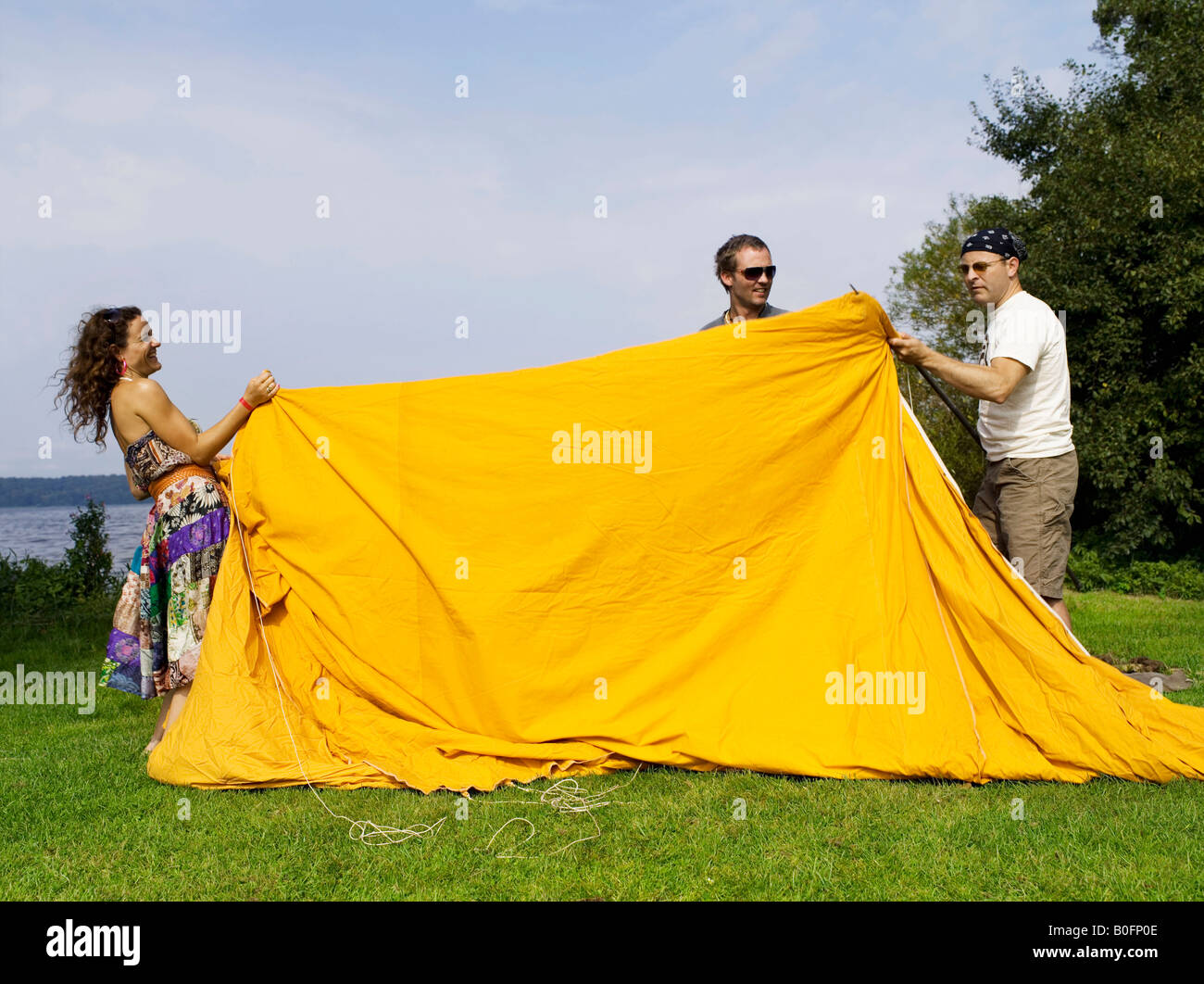 Trois personnes mise en place d'une tente Banque D'Images