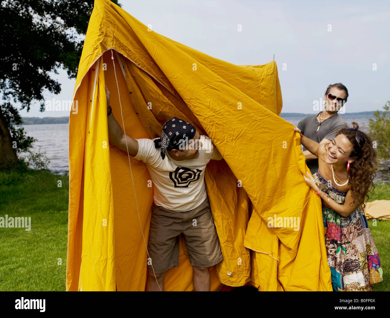Trois personnes mise en place d'une tente Banque D'Images