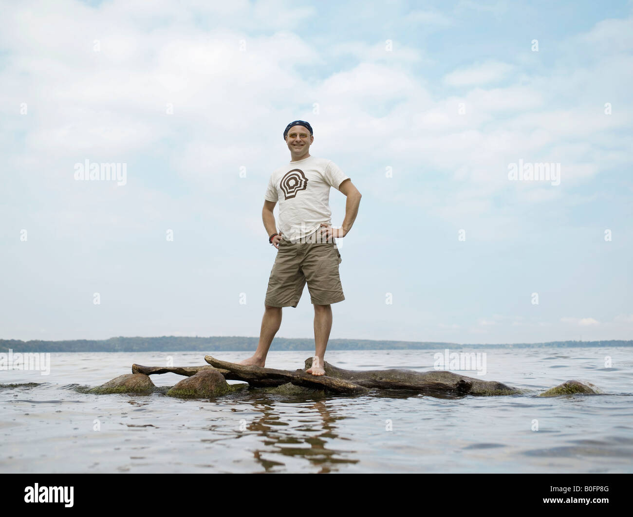 Homme debout sur des rochers dans l'eau Banque D'Images