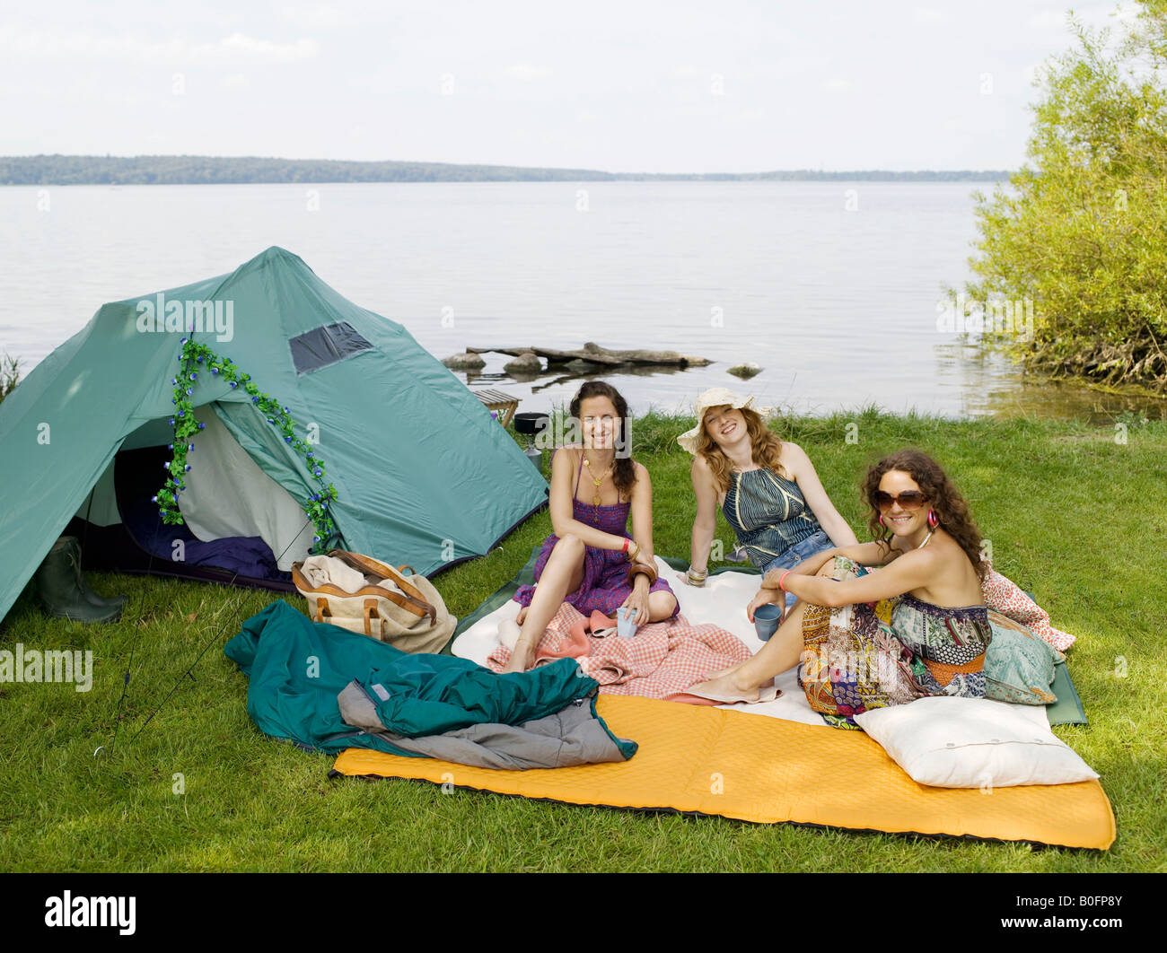 Trois femmes camping au bord de l'eau Banque D'Images
