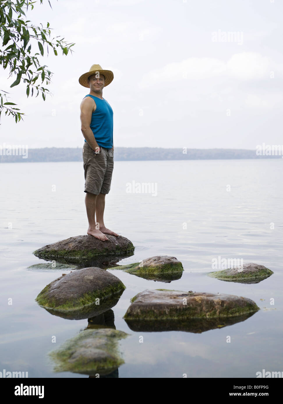 Homme debout sur la pierre dans l'eau Banque D'Images