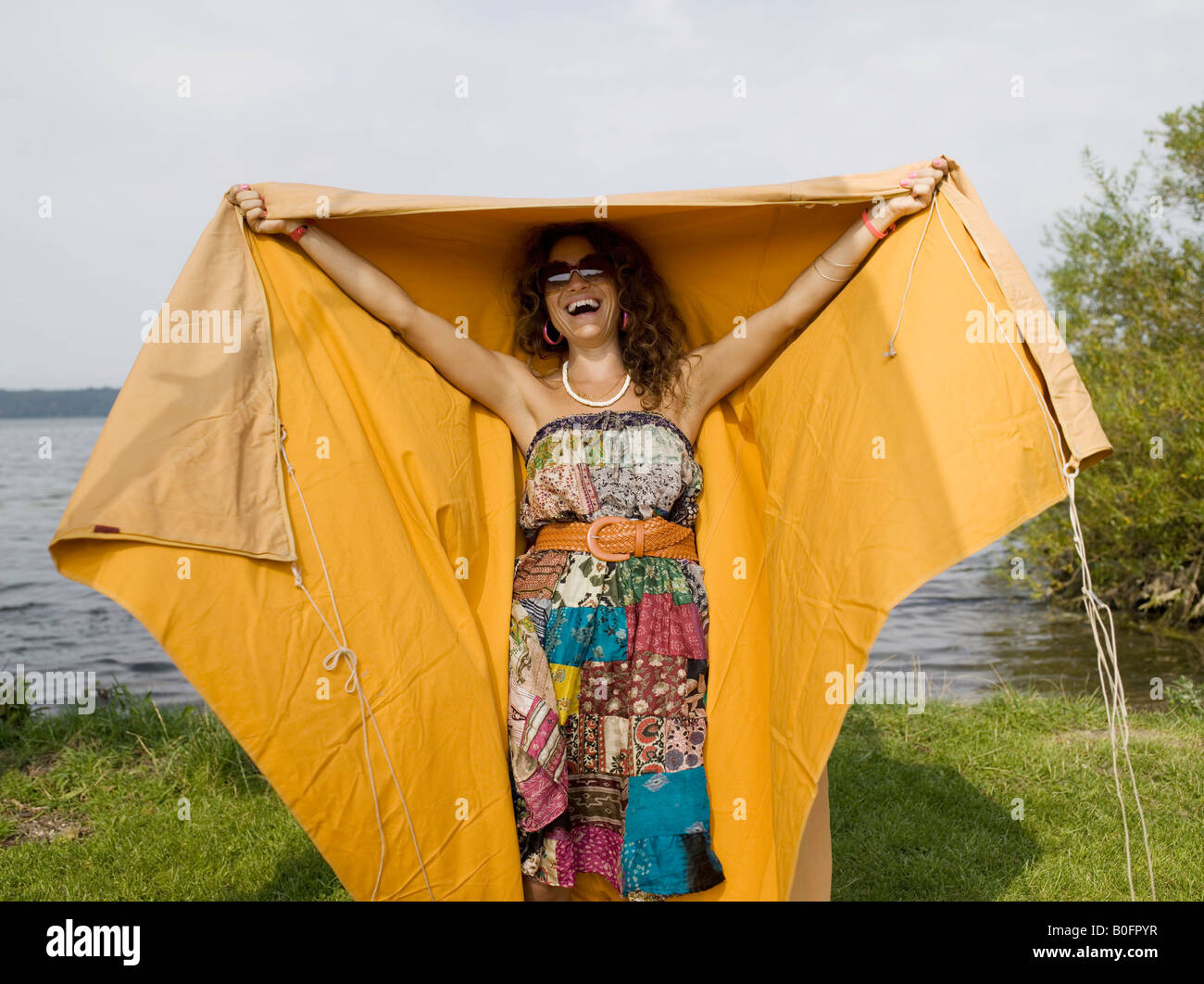 Femme en riant et debout sous la tente Banque D'Images