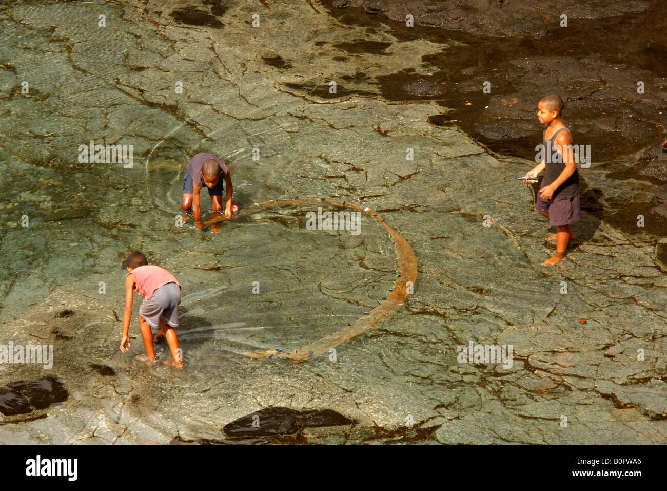 Les enfants à la pêche dans l'eau jusqu'aux genoux en Ponta do Sol sur l'île de Santo Antao Afrique Cap-vert Banque D'Images