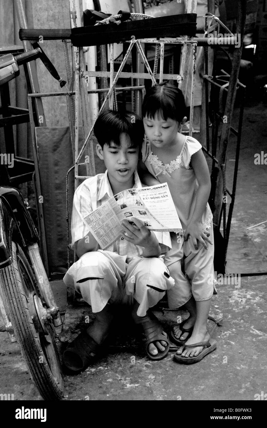 Les enfants à la lecture des bandes dessinées marché klong toei, Bangkok Banque D'Images