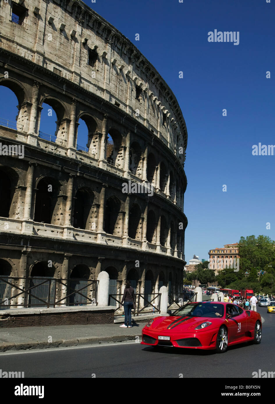 Un rouge Ferrari 430 Scuderia affaiblies par le Colisée à Rome, Italie. Banque D'Images