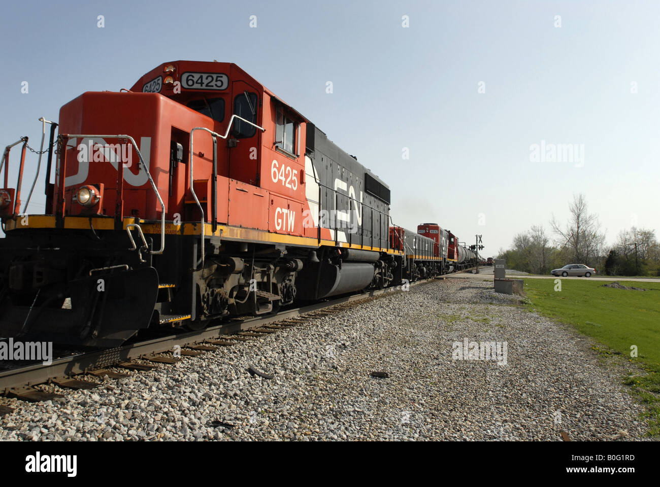 Un train de marchandises du Canadien National traverse un chemin rural dans le midwest des États-Unis près de Chicago. Banque D'Images