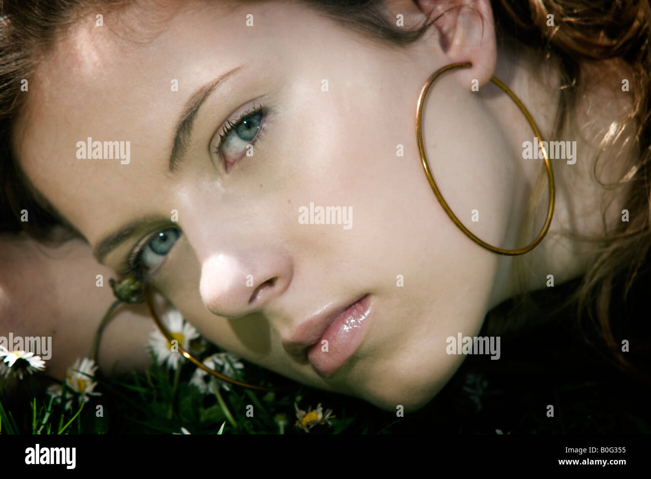 Laura une fille de seize ans portant sur l'herbe dans les marguerites Banque D'Images